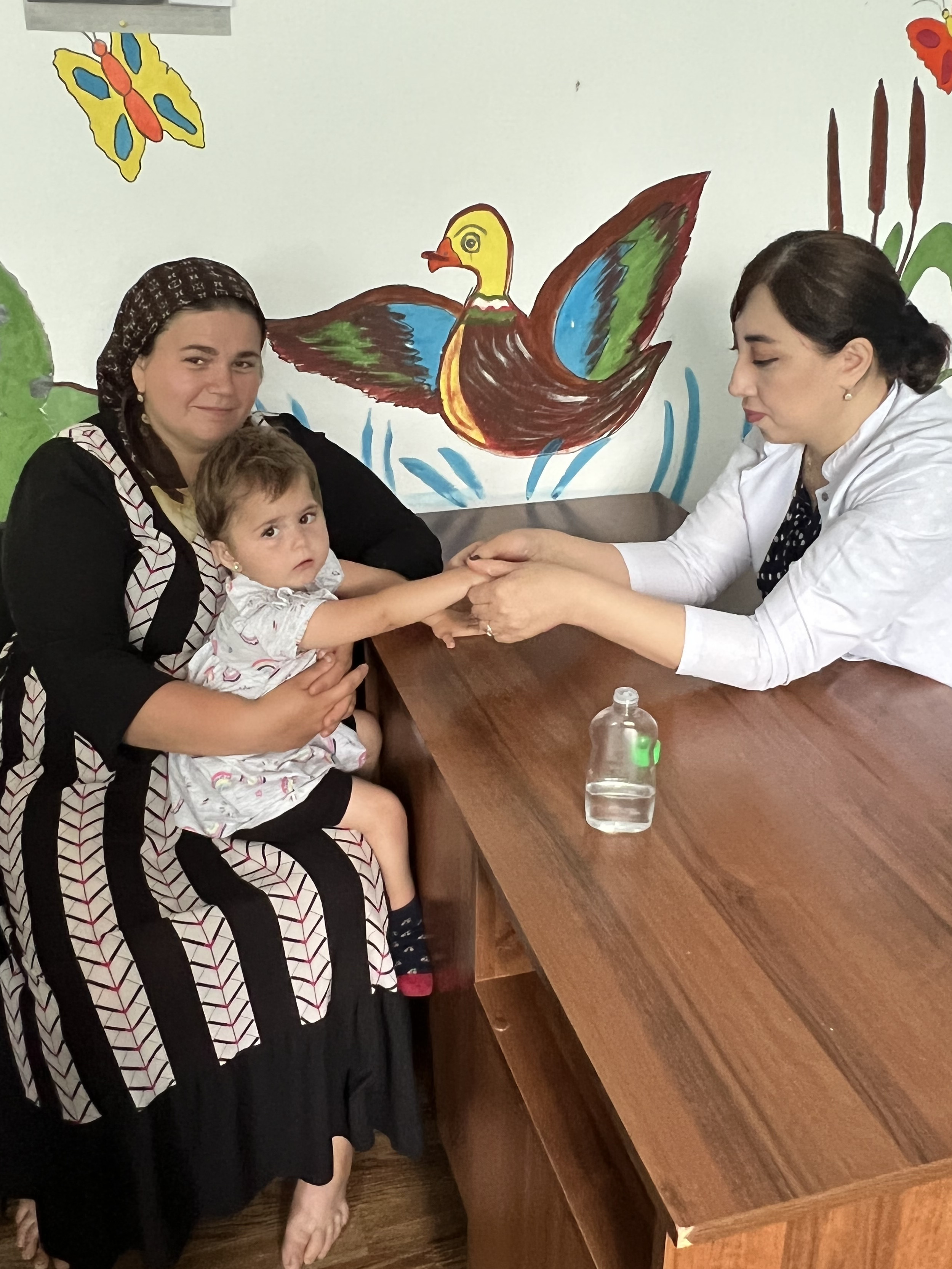 Воспитатель Алхасова Нафира проводит пальчиковый массаж подопечной центра Гаджинасуровой Заире.