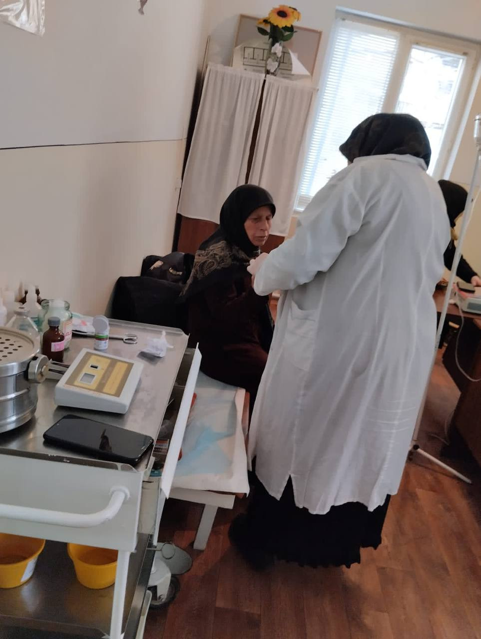 Социальный работник 1 отд. СО на дому Хадисова Хапизат при сопровождении своих подопечных в участковую больницу для проведения диспансеризации.