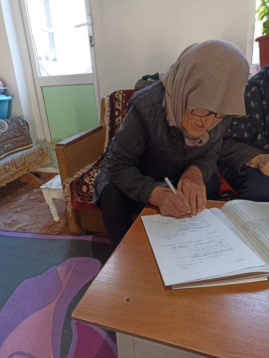 Подопечная социального работника 1 отд. СО на дому Ахмедова Багавудина ставит отметку в журнале, об оказании ей социальных услуг.