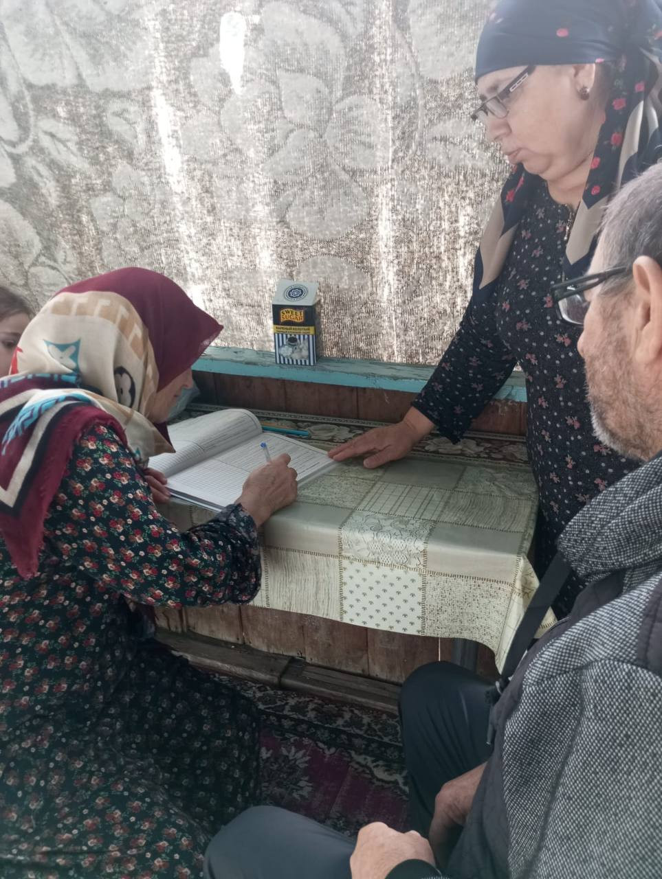 Подопечная социального работника 1 отд. СО на дому Напилуновой Нуржавгар ставит подпись в дневнике соц.работника,об оказании ей социальных услуг.